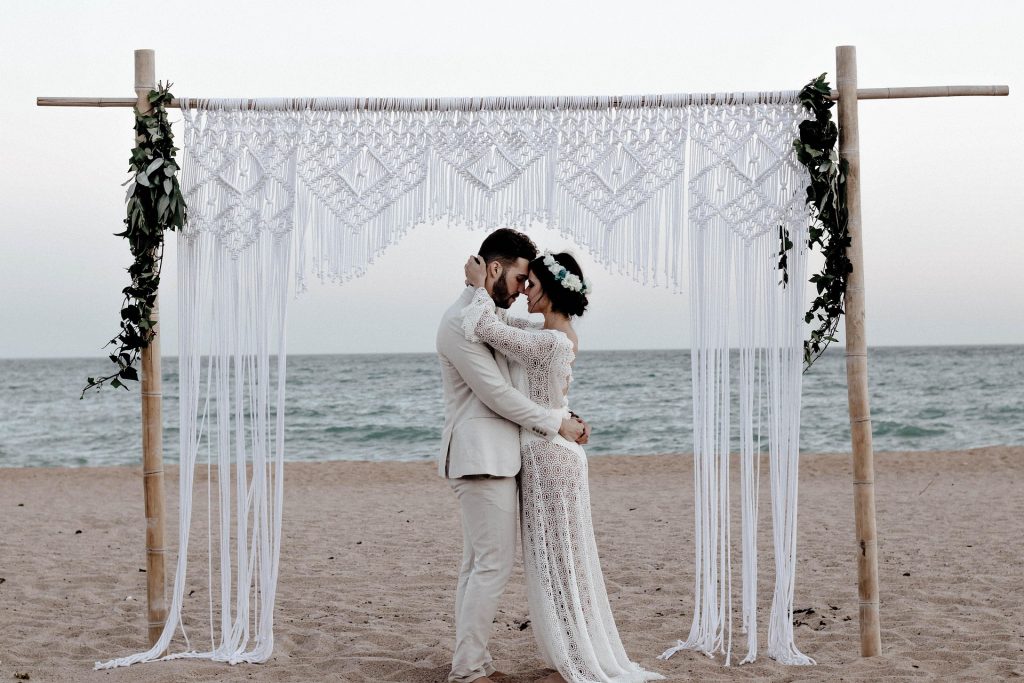 a couple hugging each other at their beach wedding venue