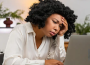 a lady staring at her laptop tired