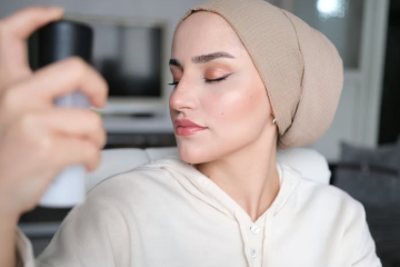 Woman applying setting spray after full makeup routine