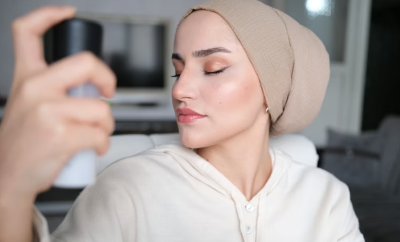 Woman applying setting spray after full makeup routine