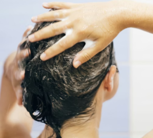 Woman applying scalp scrub during a scalp detox routine