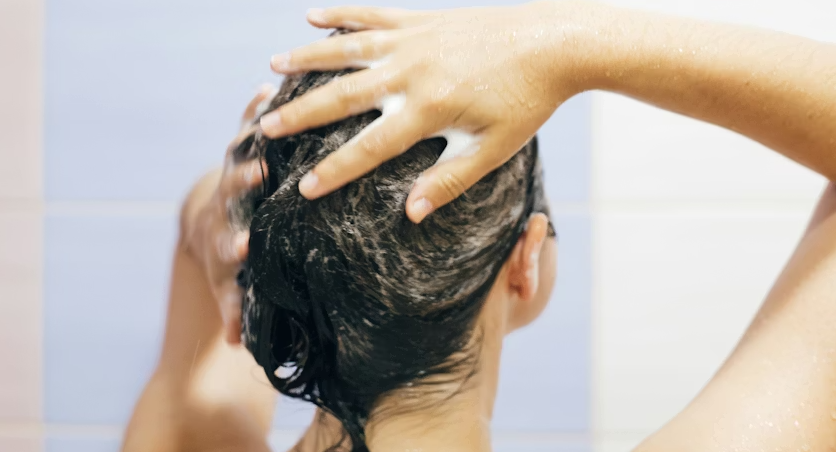 Woman applying scalp scrub during a scalp detox routine