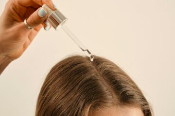 a lady applying a hair growth oil on her hair