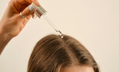 a lady applying a hair growth oil on her hair