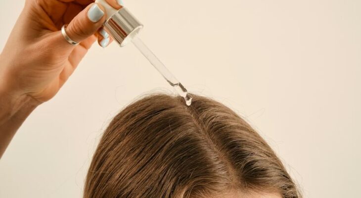 a lady applying a hair growth oil on her hair