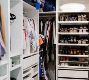 Organized closet with clothes arranged by color, folded shelves, storage baskets, and neatly lined shoes.