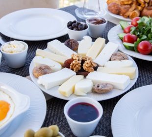 a table filled with berries, bacon, nuts and green tea