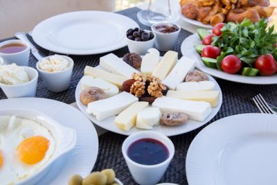 a table filled with berries, bacon, nuts and green tea
