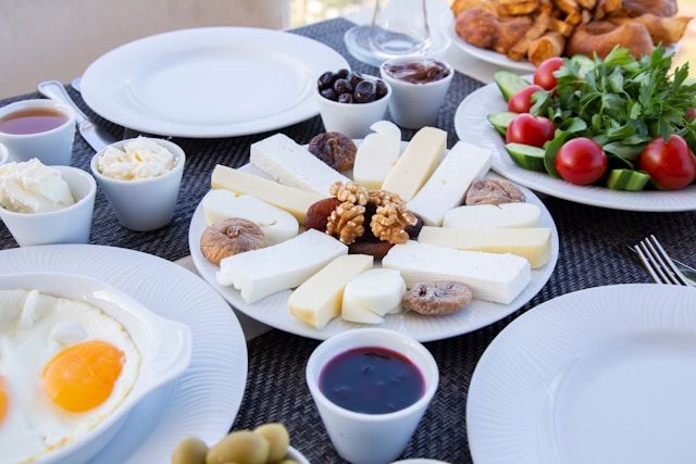 a table filled with berries, bacon, nuts and green tea