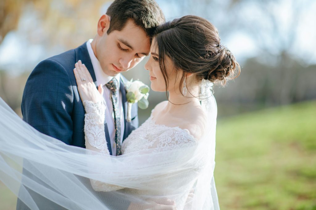 a picture of a bride and groom leaning into each other