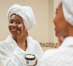 Woman applying natural clay mask on clean skin