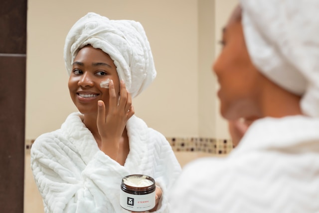 Woman applying natural clay mask on clean skin