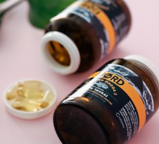 Assorted vitamins and supplements arranged on a table representing essential nutrients for women’s health.