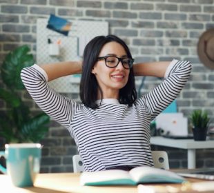 Person working at a desk with a notebook, laptop, and morning light, representing daily productivity habits, focused work routines, and structured time management.