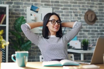 Person working at a desk with a notebook, laptop, and morning light, representing daily productivity habits, focused work routines, and structured time management.